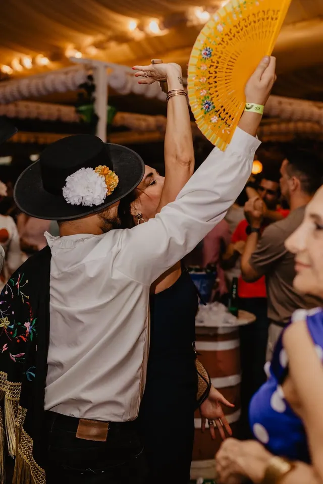 Hombre con sombrero cordobés alzando un abanico amarillo