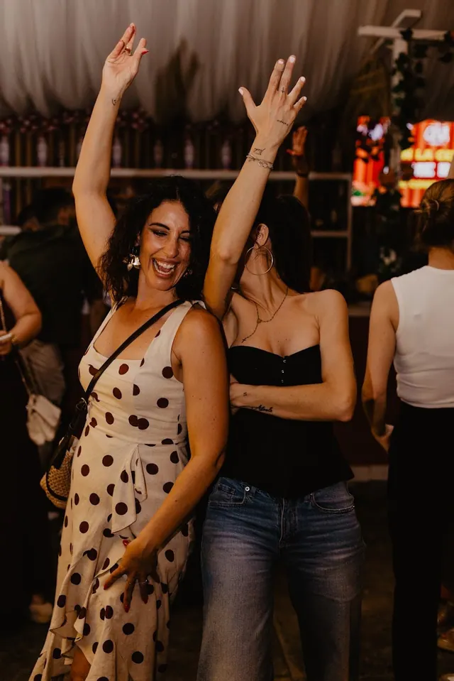 Mujeres bailando con los brazos en alto