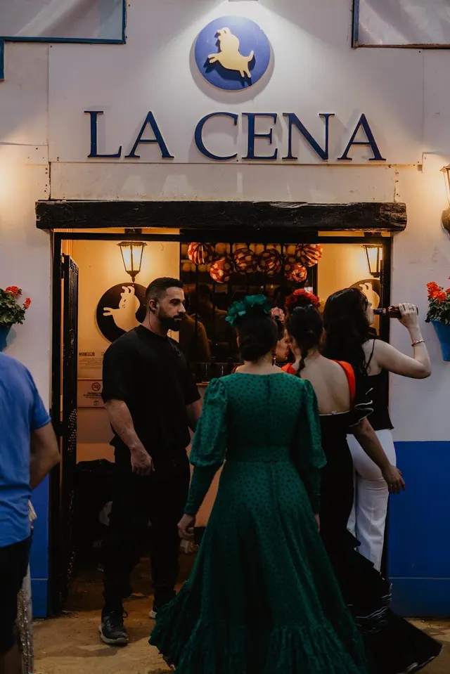 Entrada de La Cena de noche, con el rótulo «La Cena» y el emblema del toro sobre la puerta