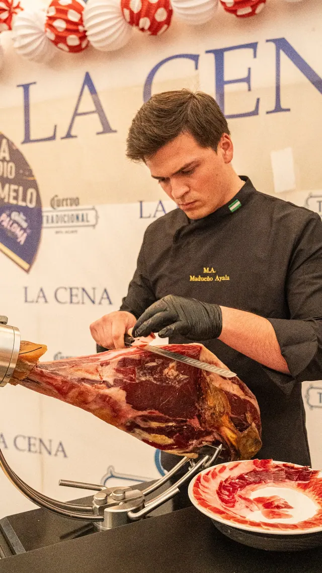 Cortador de jamón ante el rótulo de La Cena