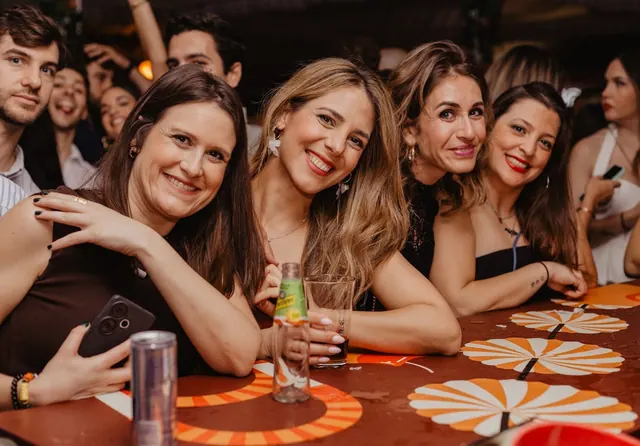 Grupo de amigas brindando en una mesa de la barra