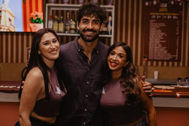 Tres amigos posando junto a la barra de La Cena